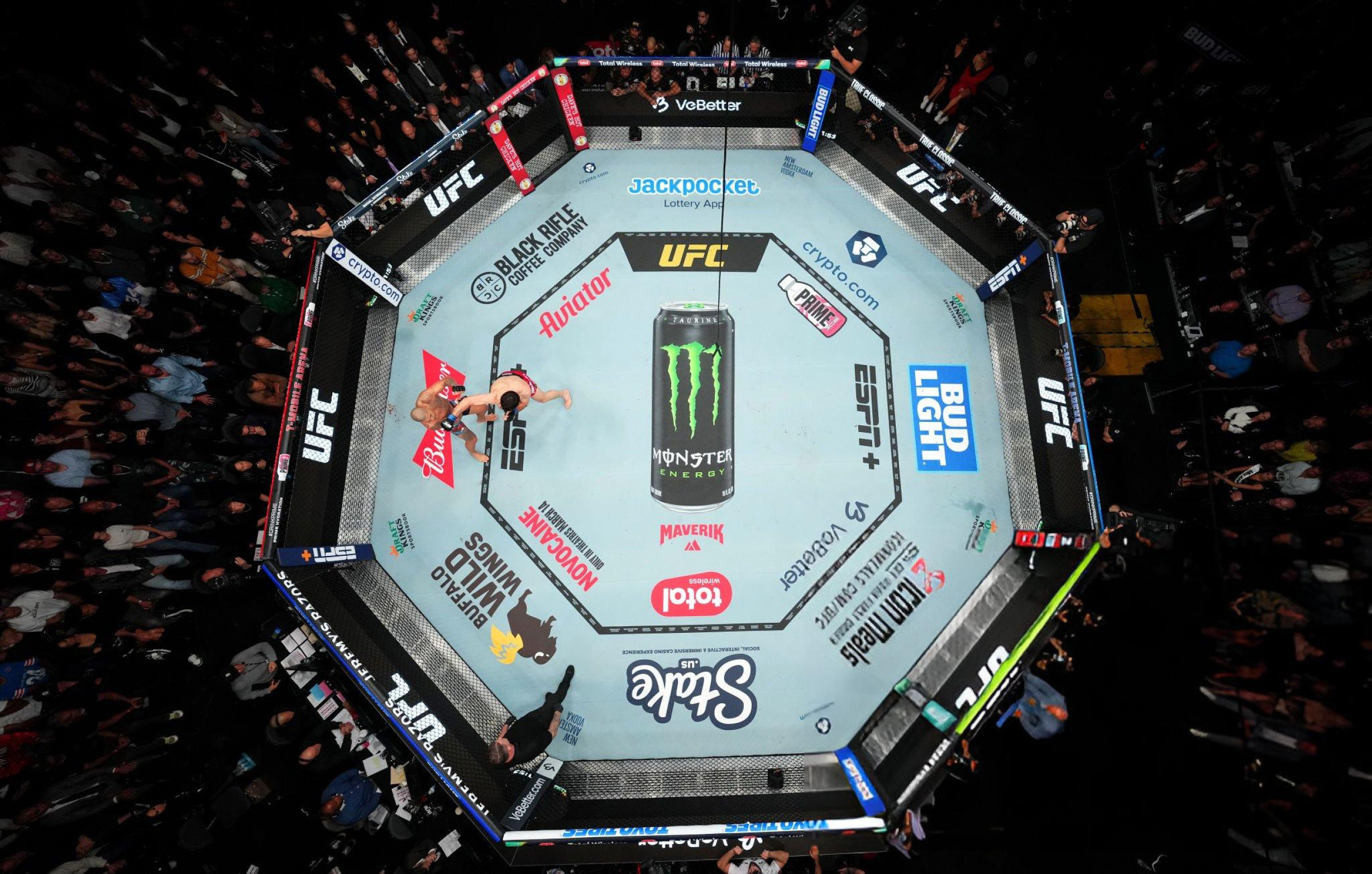 Cage Bellator 286 vide vue en plongée avec tapis couvert de logos sponsors : Monster Energy au centre, Showtime, Blackhawk, Visit Las Vegas, Bellator.com, DragonPay — illustration de l'économie du sponsoring dans les grandes organisations MMA