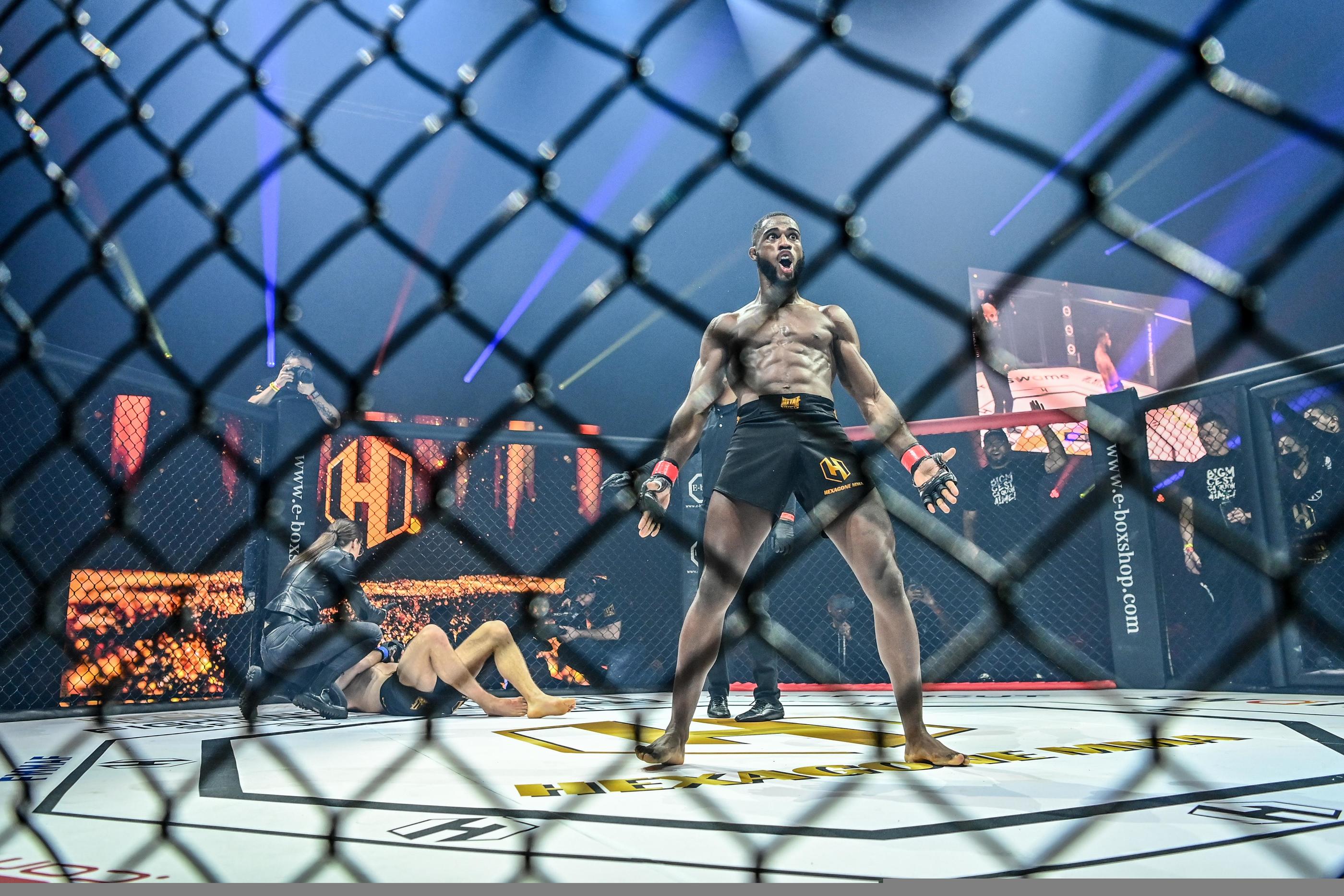 Paris sportif MMA cage victoire combattant 2026 - combattant qui célèbre dans la cage